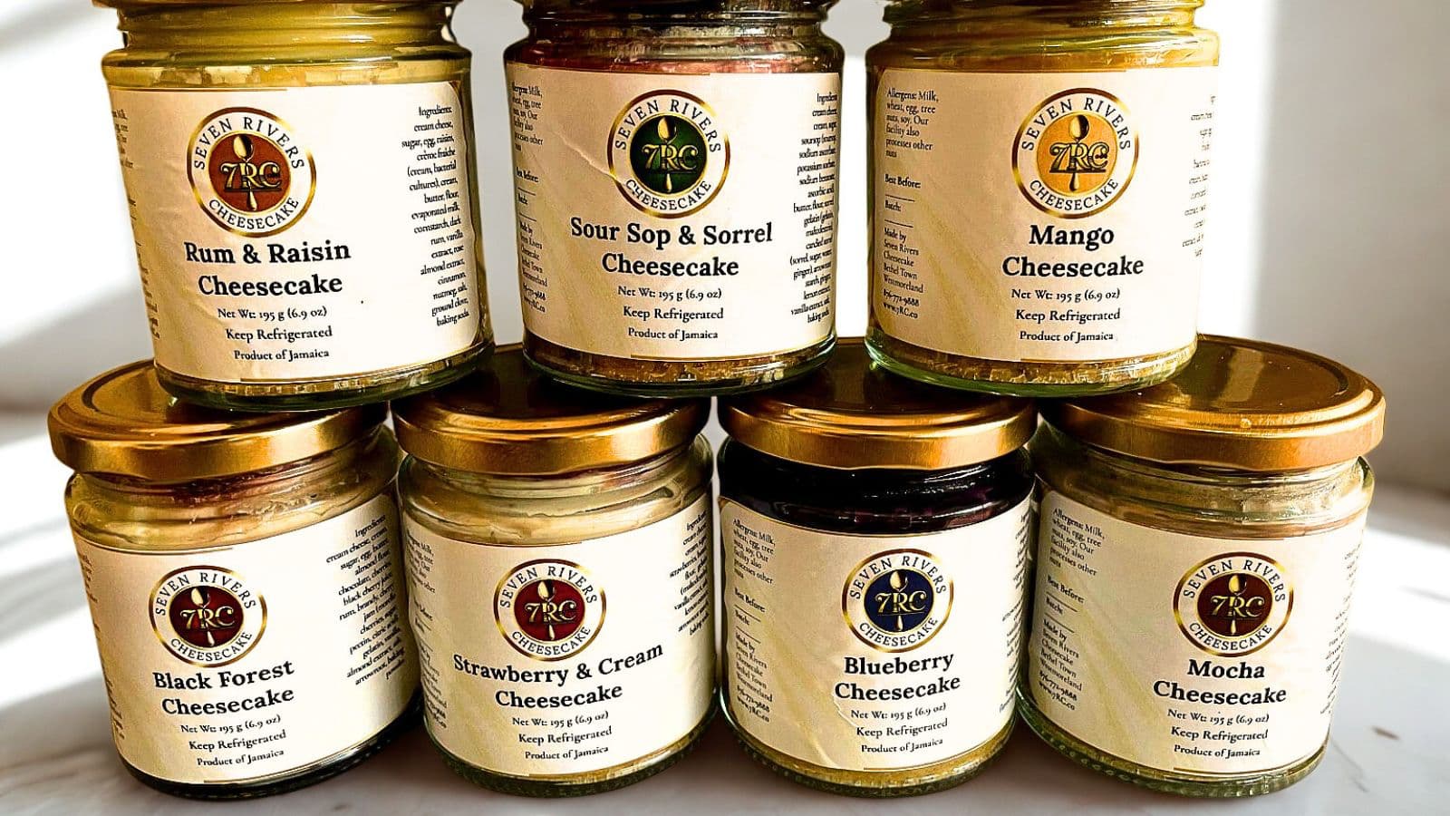 “Seven Rivers Cheesecake jar lineup featuring seven signature flavours including mango, sorrel, mocha, and more