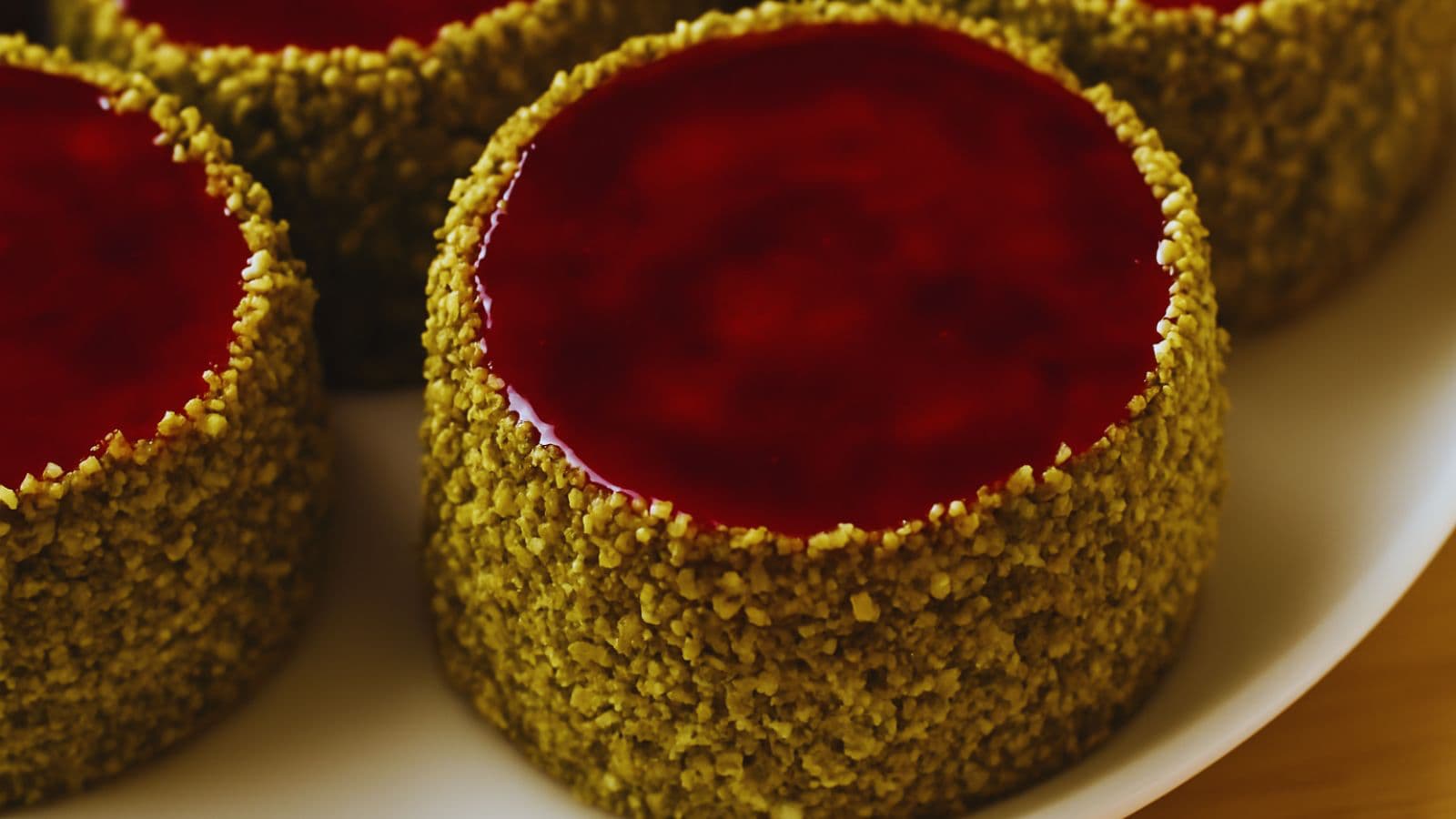 Shop Specials header image showing elegant pistachio-crusted cheesecakes topped with berry glaze — highlighting limited-time offerings.
