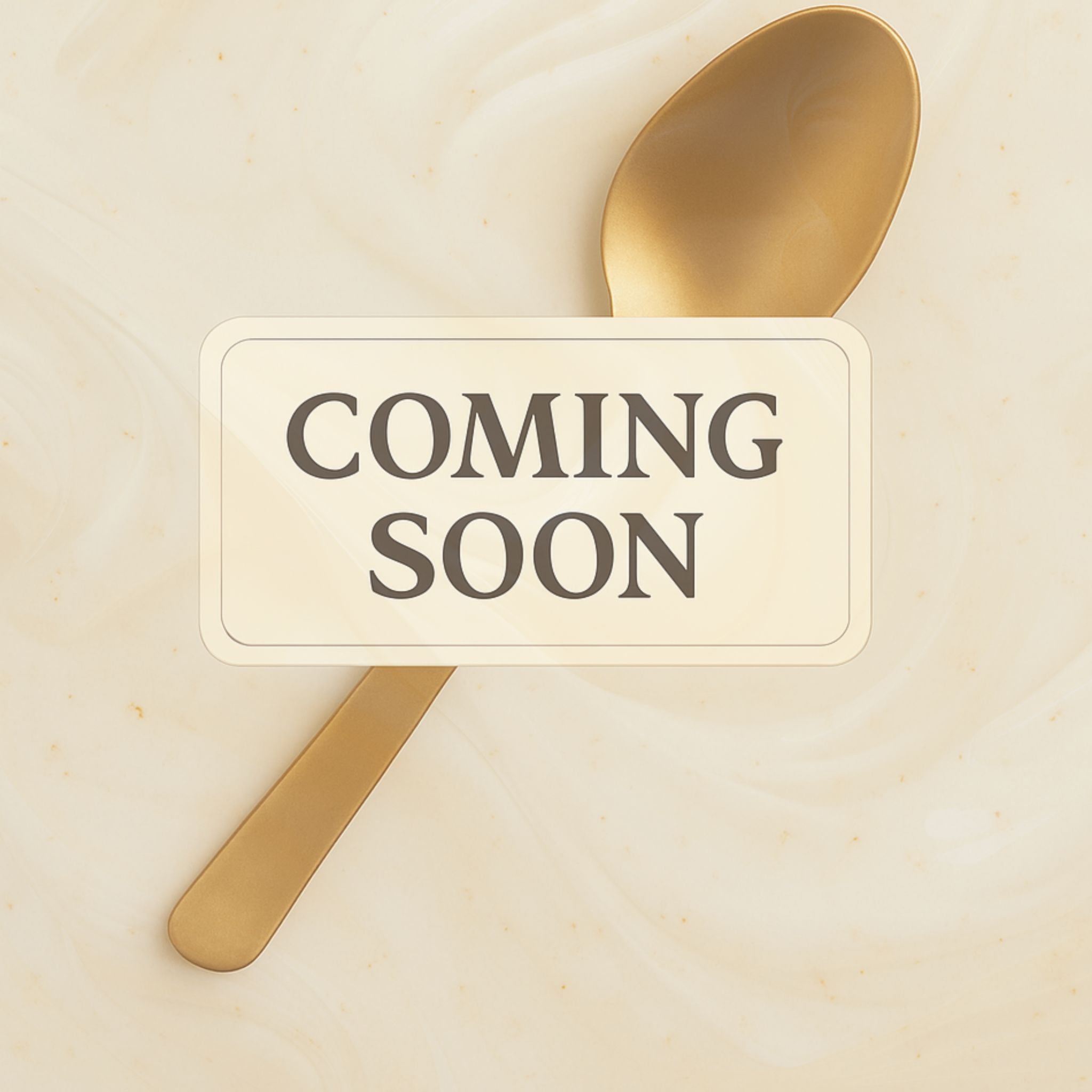 Gold spoon on swirled cream background with ‘Coming Soon’ label overlay