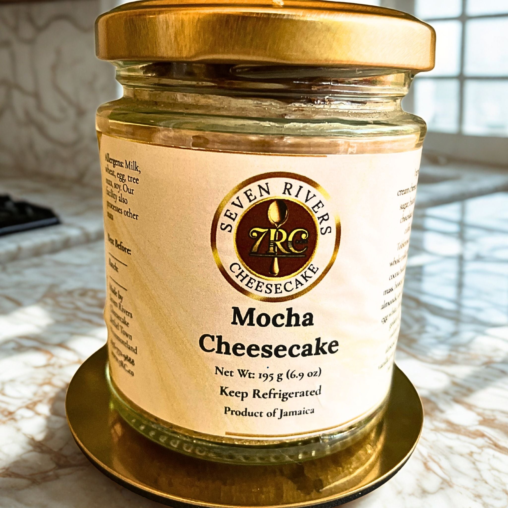 Mocha cheesecake jar with signature Seven Rivers label, set against natural light on marble surface.